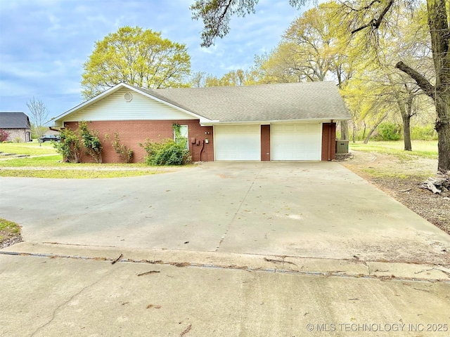 single story home with an attached garage, concrete driveway, and brick siding