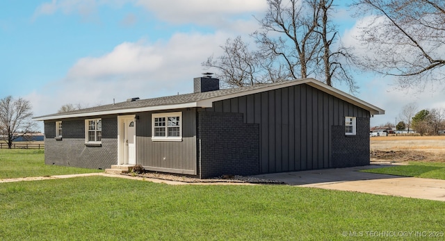 18446 E 112th St, Owasso, OK 74055 - view of front facade with brick siding, a front yard, and a chimney