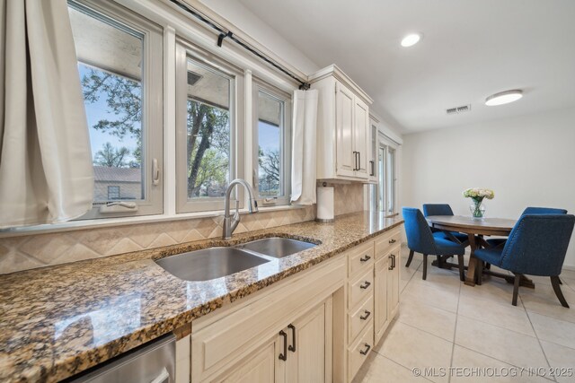 2947 S Peoria Ave, Tulsa, OK 74114 - kitchen featuring backsplash, dishwasher, visible vents, a sink, and light stone countertops