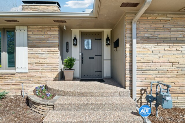 2947 S Peoria Ave, Tulsa, OK 74114 - doorway to property featuring visible vents and stone siding