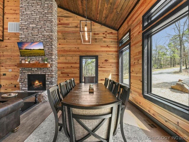1739 NW 136th Rd, Wilburton, OK 74578 - dining space featuring visible vents, wooden walls, wooden ceiling, and a fireplace