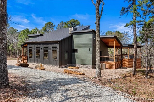 1739 NW 136th Rd, Wilburton, OK 74578 - exterior space featuring driveway, board and batten siding, and central AC