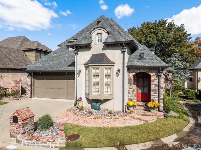 6323 E 111th Pl, Tulsa, OK 74137 - french country home with an attached garage, stucco siding, driveway, and roof with shingles