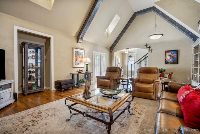 6323 E 111th Pl, Tulsa, OK 74137 - living area featuring wood finished floors, high vaulted ceiling, arched walkways, stairway, and a skylight