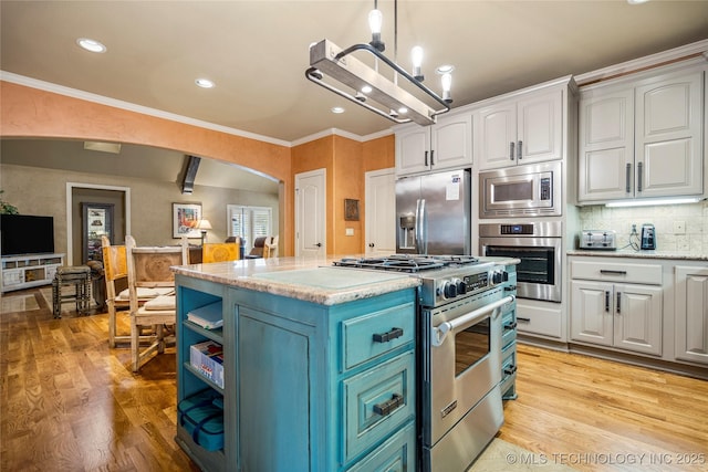 6323 E 111th Pl, Tulsa, OK 74137 - kitchen with appliances with stainless steel finishes, white cabinetry, arched walkways, a center island, and ornamental molding