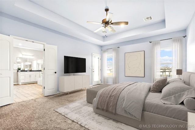 3316 W Jackson St, Broken Arrow, OK 74012 - bedroom featuring ensuite bathroom, a ceiling fan, visible vents, a raised ceiling, and light colored carpet