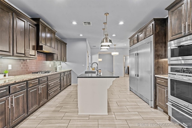 3316 W Jackson St, Broken Arrow, OK 74012 - kitchen with visible vents, under cabinet range hood, a sink, decorative backsplash, and built in appliances