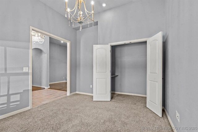 3316 W Jackson St, Broken Arrow, OK 74012 - unfurnished bedroom featuring carpet flooring, a chandelier, arched walkways, and a towering ceiling