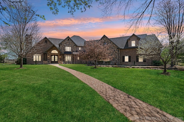 9931 N Chadford Rd, Owasso, OK 74055 - view of front of property featuring stone siding, a yard, and french doors