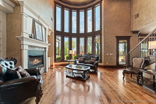 9931 N Chadford Rd, Owasso, OK 74055 - living room featuring a high end fireplace, a high ceiling, wood-type flooring, and stairs