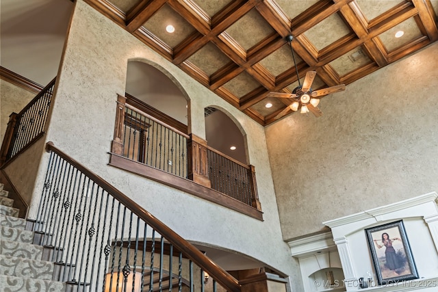 9931 N Chadford Rd, Owasso, OK 74055 - staircase with a high ceiling, coffered ceiling, a ceiling fan, beam ceiling, and a textured wall
