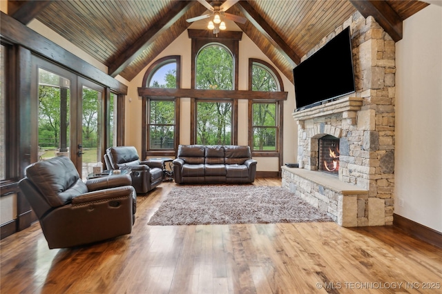 living area featuring french doors, a fireplace, wooden ceiling, high vaulted ceiling, and beamed ceiling