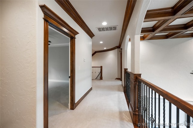 hall with ornamental molding, light colored carpet, visible vents, and an upstairs landing