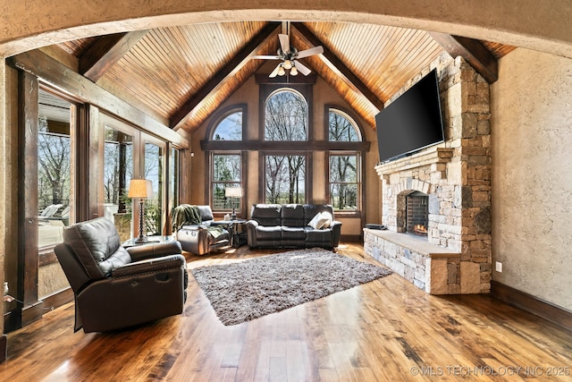9931 N Chadford Rd, Owasso, OK 74055 - living room featuring a wood ceiling with exposed beams, hardwood / wood-style flooring, a ceiling fan, a fireplace, and high vaulted ceiling