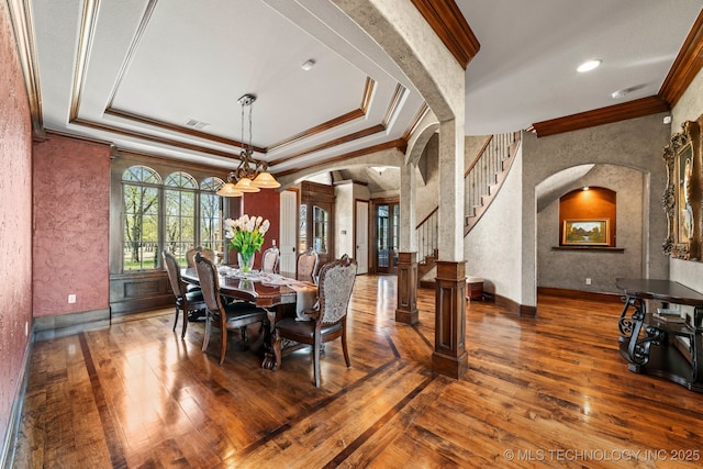 9931 N Chadford Rd, Owasso, OK 74055 - dining room featuring arched walkways, ornamental molding, hardwood / wood-style flooring, and a raised ceiling