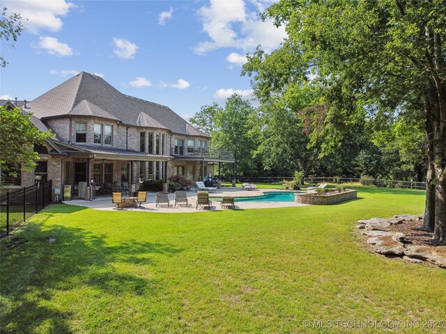 back of property featuring a balcony, a fenced backyard, a fenced in pool, a patio area, and a lawn