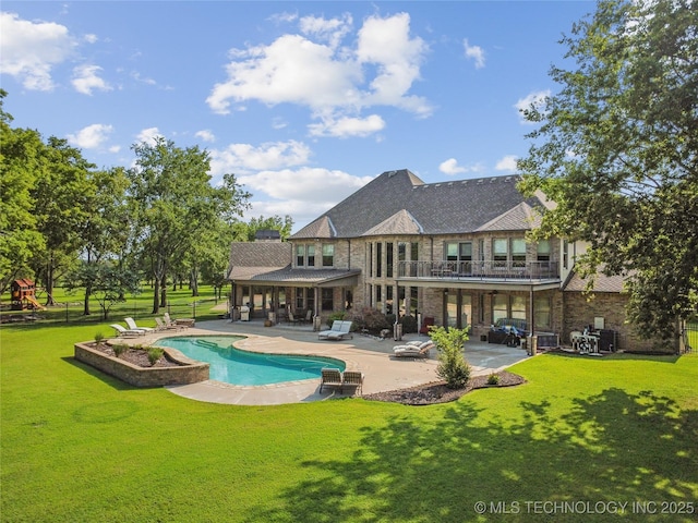 back of house featuring brick siding, an outdoor pool, a balcony, a patio, and a yard
