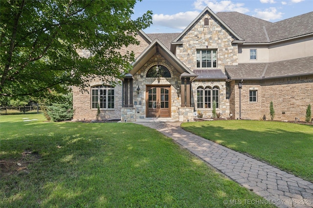 view of front of property featuring a front lawn, french doors, and stone siding