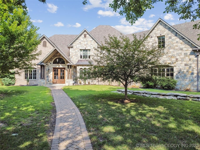 french provincial home with french doors, a front lawn, and stone siding