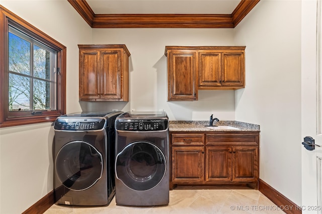laundry area with a sink, ornamental molding, cabinet space, and washing machine and dryer
