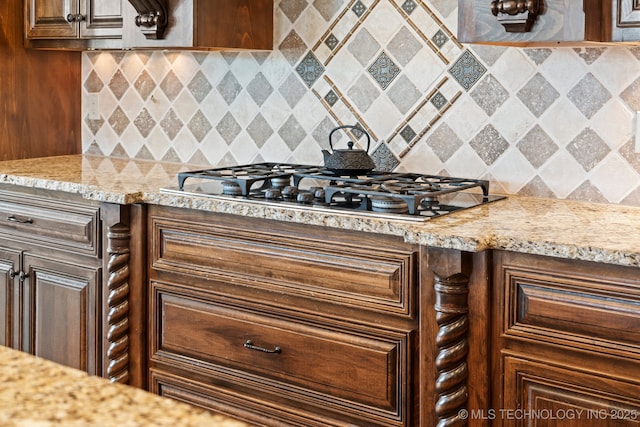 9931 N Chadford Rd, Owasso, OK 74055 - kitchen with stainless steel gas stovetop, decorative backsplash, light stone counters, and dark brown cabinets