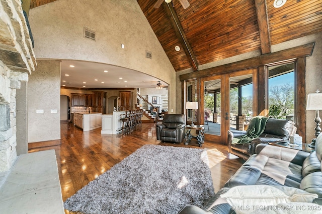9931 N Chadford Rd, Owasso, OK 74055 - living room featuring arched walkways, high vaulted ceiling, a wood ceiling with exposed beams, french doors, and ceiling fan