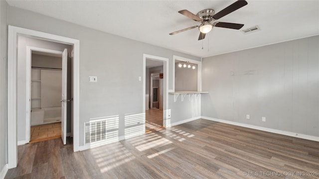 345 N Pine, Dewey, OK 74029 - unfurnished bedroom featuring wood finished floors, baseboards, a spacious closet, and a ceiling fan