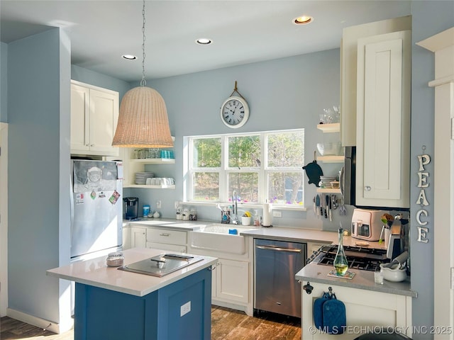 kitchen with white cabinetry, light countertops, open shelves, a sink, and appliances with stainless steel finishes
