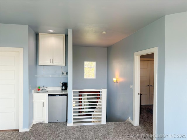 bar featuring carpet flooring, a sink, dishwasher, indoor bar, and baseboards