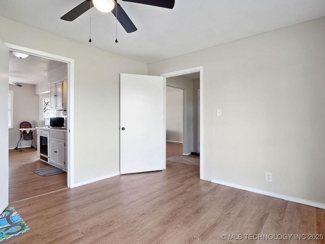 511 Tandy Walker, Silo, OK 74701 - interior space with baseboards, light wood-type flooring, a ceiling fan, and beverage cooler