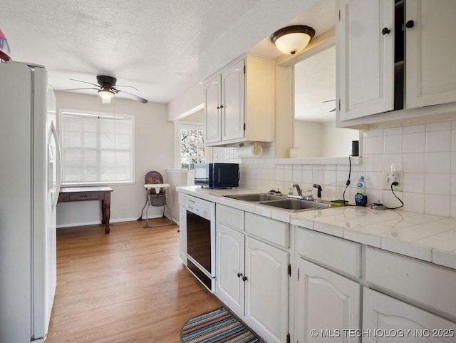 511 Tandy Walker, Silo, OK 74701 - kitchen with freestanding refrigerator, ceiling fan, light wood finished floors, dishwasher, and a sink