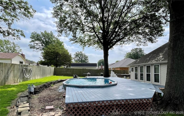 view of swimming pool featuring a fenced in pool, a fenced backyard, and a deck