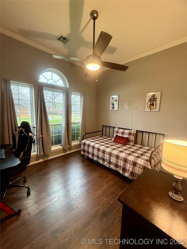 bedroom featuring dark wood-type flooring, ornamental molding, visible vents, and ceiling fan