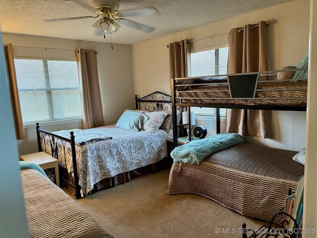 bedroom with a textured ceiling, ceiling fan, and carpet