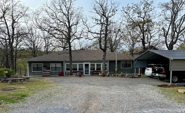 view of front facade featuring a shingled roof and gravel driveway