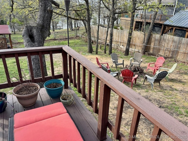 wooden terrace with an outdoor fire pit and fence
