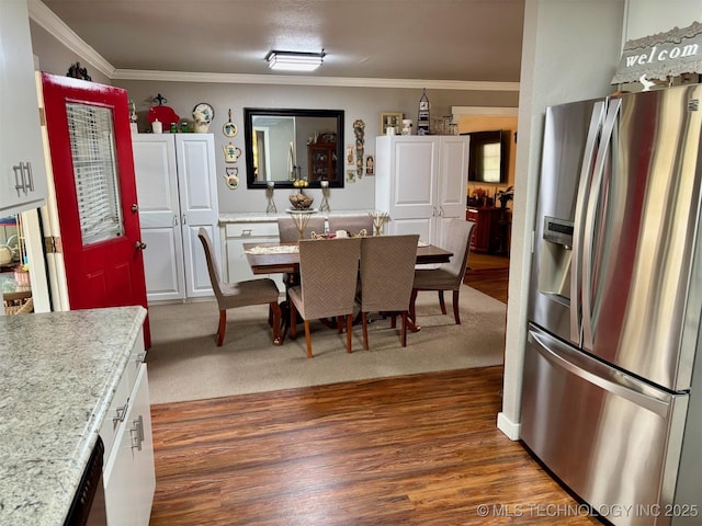 kitchen with dark wood-style flooring, ornamental molding, and stainless steel refrigerator with ice dispenser