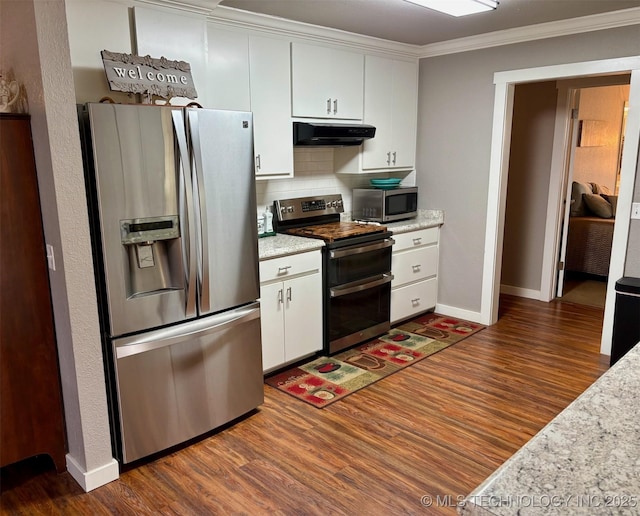 kitchen with white cabinetry, crown molding, dark wood-style flooring, under cabinet range hood, and appliances with stainless steel finishes