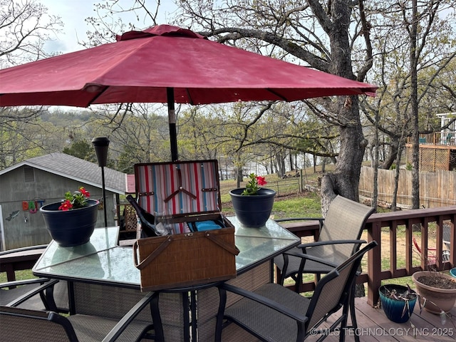 deck featuring outdoor dining area and fence