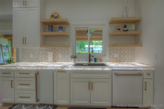 kitchen with open shelves, dishwasher, backsplash, and a sink