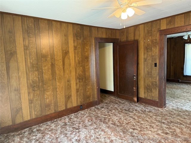 609 N E St, Mcalester, OK 74501 - spare room featuring wood walls, ceiling fan, and carpet