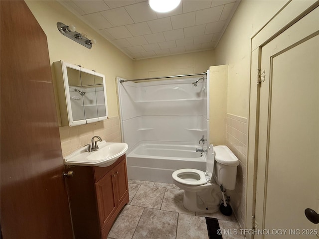 609 N E St, Mcalester, OK 74501 - full bath featuring vanity, tile patterned floors,  shower combination, toilet, and tile walls