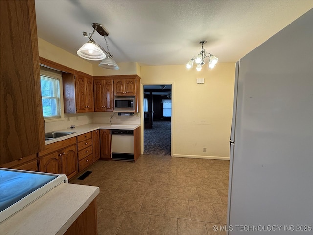 609 N E St, Mcalester, OK 74501 - kitchen featuring a sink, light countertops, white appliances, and an inviting chandelier
