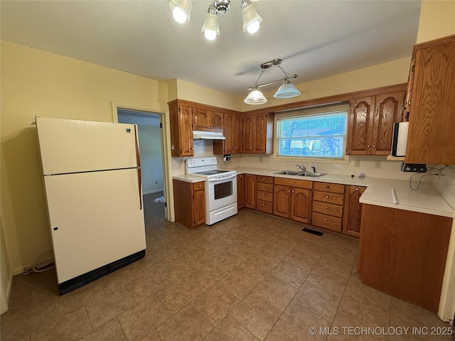 609 N E St, Mcalester, OK 74501 - kitchen featuring light countertops, brown cabinetry, white appliances, and under cabinet range hood
