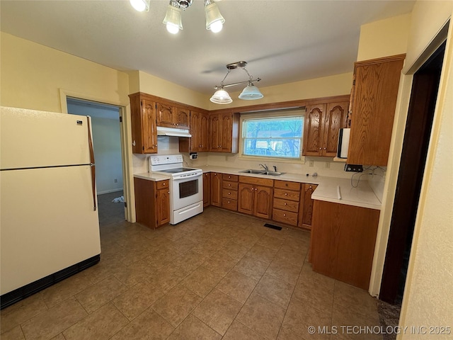 609 N E St, Mcalester, OK 74501 - kitchen with under cabinet range hood, white appliances, brown cabinets, and light countertops