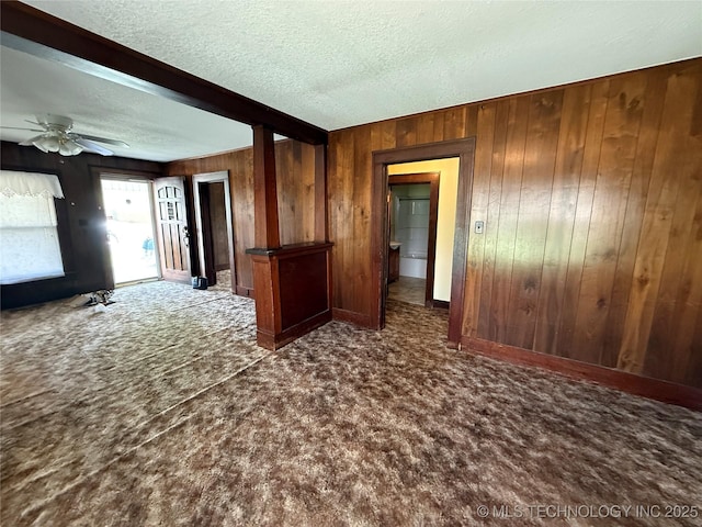 609 N E St, Mcalester, OK 74501 - carpeted spare room with wood walls, a textured ceiling, and a ceiling fan
