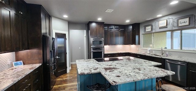 17078 S 11th W Ave, Glenpool, OK 74033 - kitchen with black appliances, dark wood-type flooring, backsplash, a center island, and recessed lighting