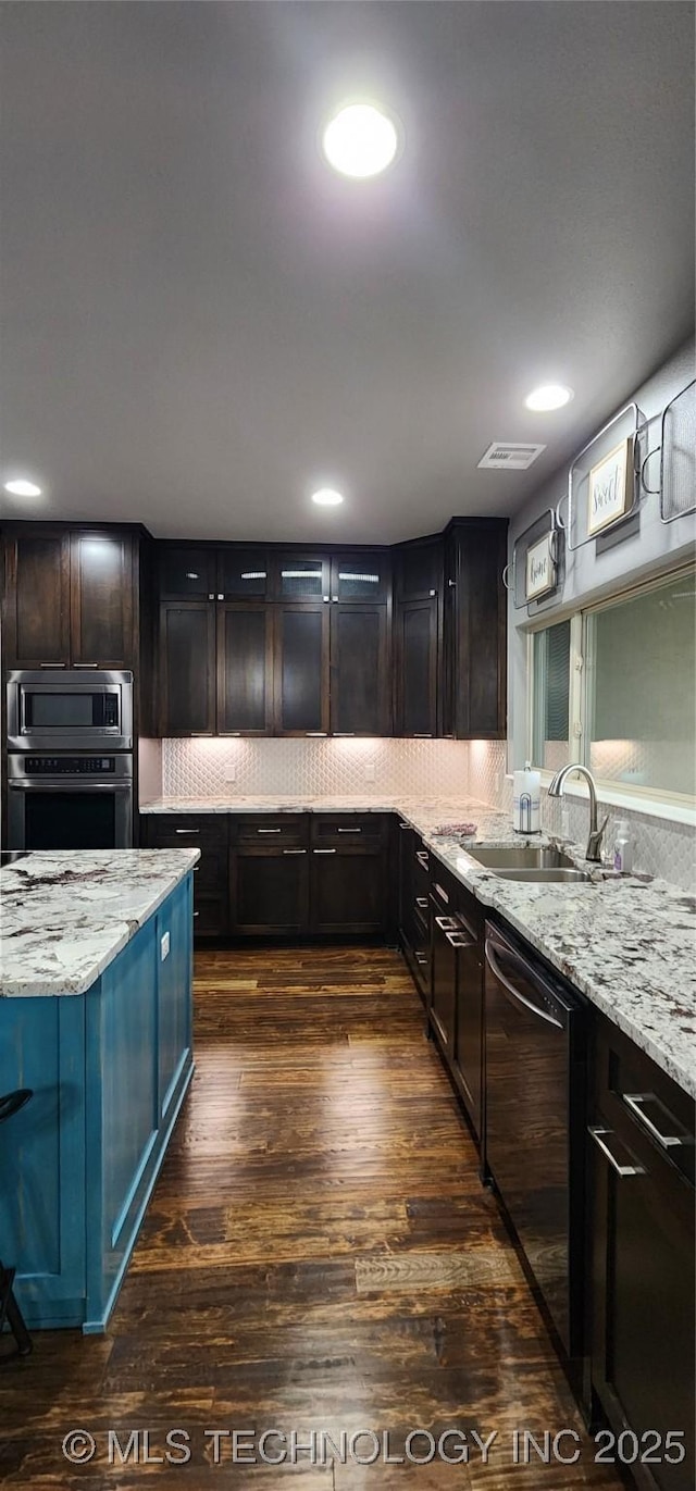 17078 S 11th W Ave, Glenpool, OK 74033 - kitchen with appliances with stainless steel finishes, light stone counters, dark wood-style floors, backsplash, and recessed lighting