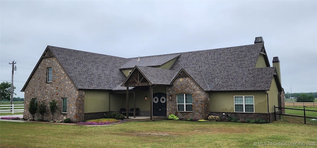 view of front of property featuring a front yard, stone siding, a chimney, and fence