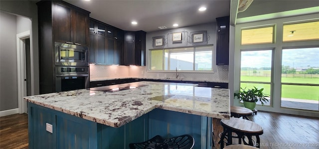 17078 S 11th W Ave, Glenpool, OK 74033 - kitchen featuring oven, stainless steel microwave, dark wood-type flooring, decorative backsplash, and recessed lighting